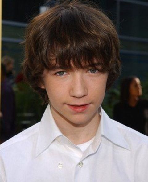 Liam Aiken in a white shirt poses a picture.